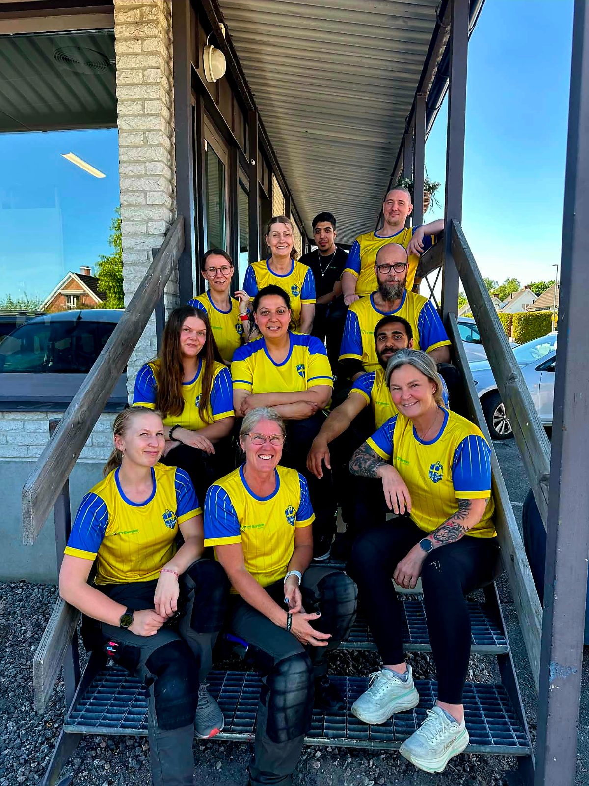 TT Service Solution-teamet i gulblå tröjor utanför kontoret